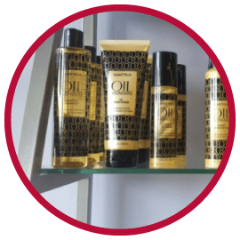 Several bottles of oil are on a glass shelf