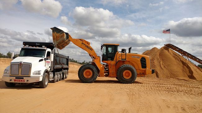 Front End Loader Dumping Sand into a Dumptruck