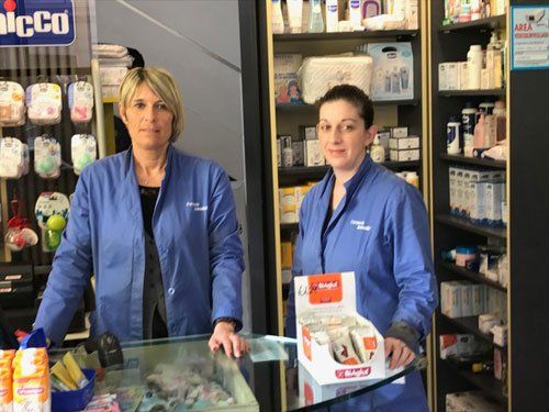 commesse davanti al bancone della farmacia