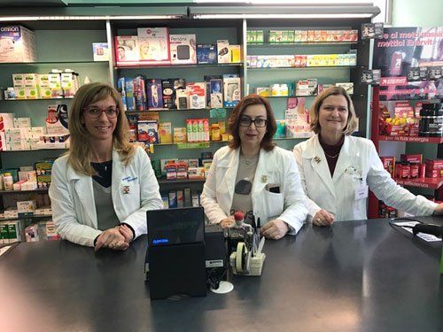 farmaciste sorridenti davanti alla cassa della farmacia