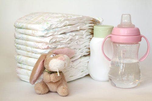 pannolini, due biberon e un peluche a forma di coniglietto
