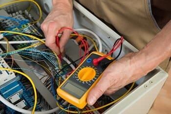 Seattle High Voltage Electric Contractor — Electrician Checking Fuse Box in Burien, WA Seattle High Voltage Electric Contractor — Electrician Checking Fuse Box in Burien, WA