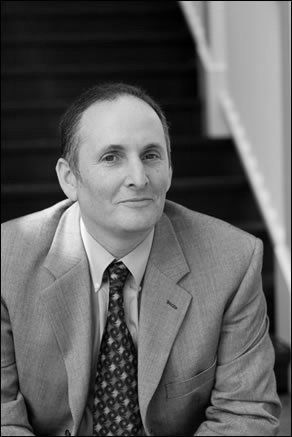 A black and white photo of Richard Zieman in a suit and tie