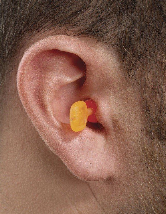 A close up of a person 's ear with ear plugs in it.