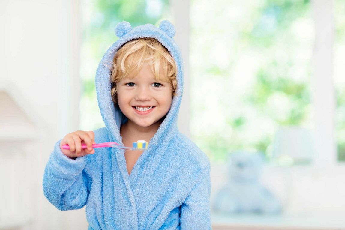Child Smiling While Holding A Toot Brush — Lima, OH — Whole Health Dentistry