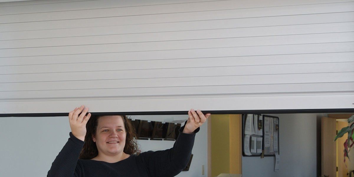 Woman lifting roller door. Woman lifting roller door.