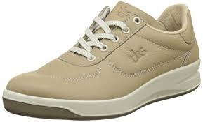 Une paire de baskets beiges à lacets blancs sur fond blanc.