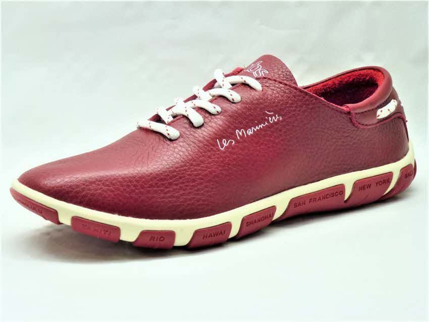 Une paire de chaussures rouges avec des lacets blancs sur une surface blanche.