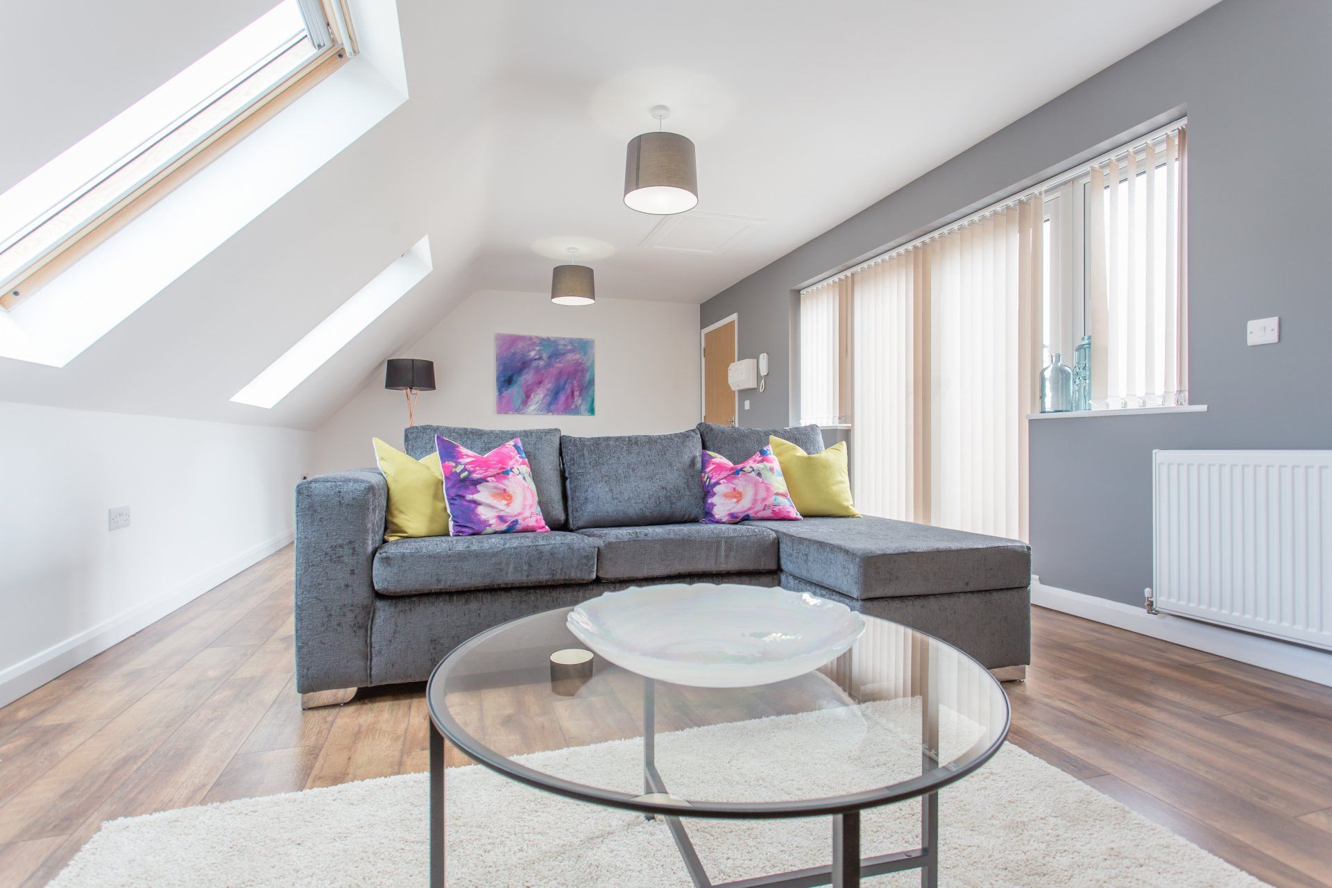 Modern living room with sofa, coffee table, and natural lighting in a serviced apartment.