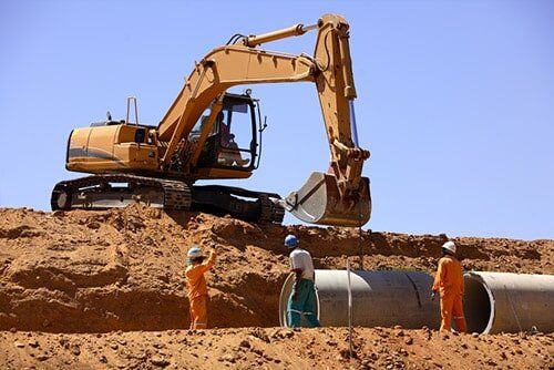 Excavator Pipe Laying — Drilling, exacavation and earthworks in Kiama, NSW Excavator Pipe Laying — Drilling, exacavation and earthworks in Kiama, NSW