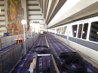 An empty train station with a purple carpet and a fence