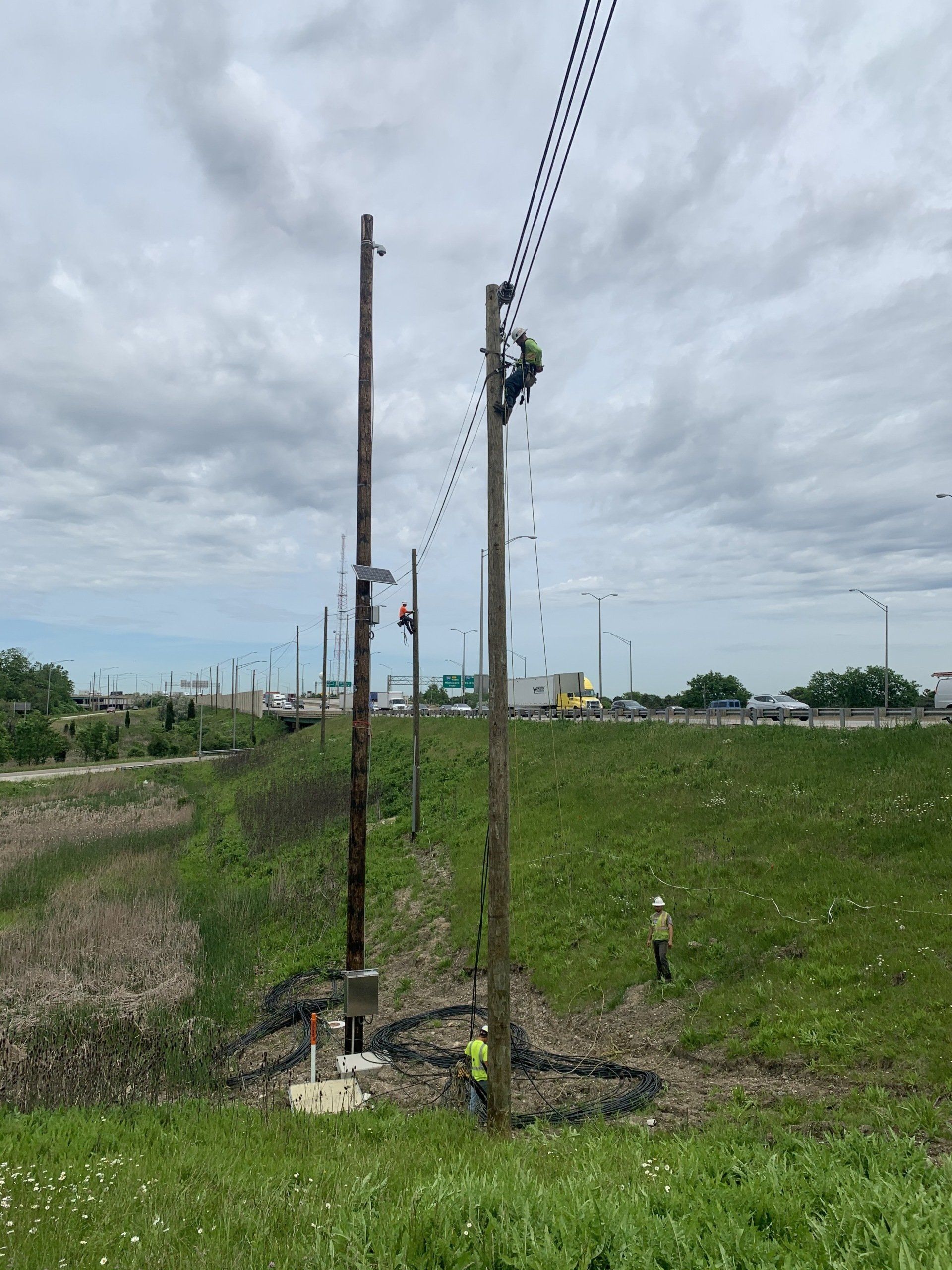 A man is working on a power line in a field.