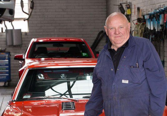 mechanic owner in front of car