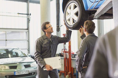 man inspecting car wheel