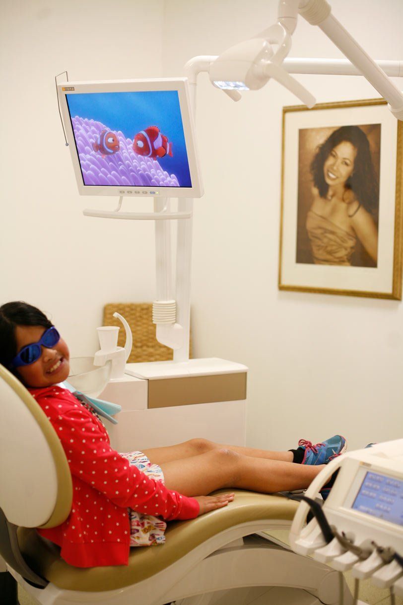 Serving families girl with sunglasses in dentist chair