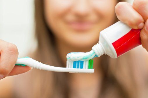 Fluoride putting toothpaste on brush