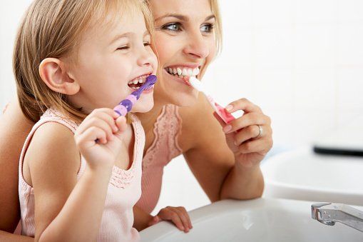 Prevention mom and girl brushing teeth