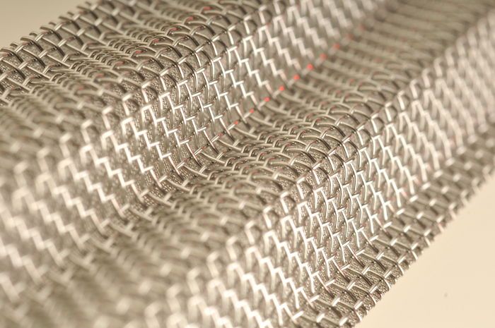 Woven metal mesh filters with synthetic overlay