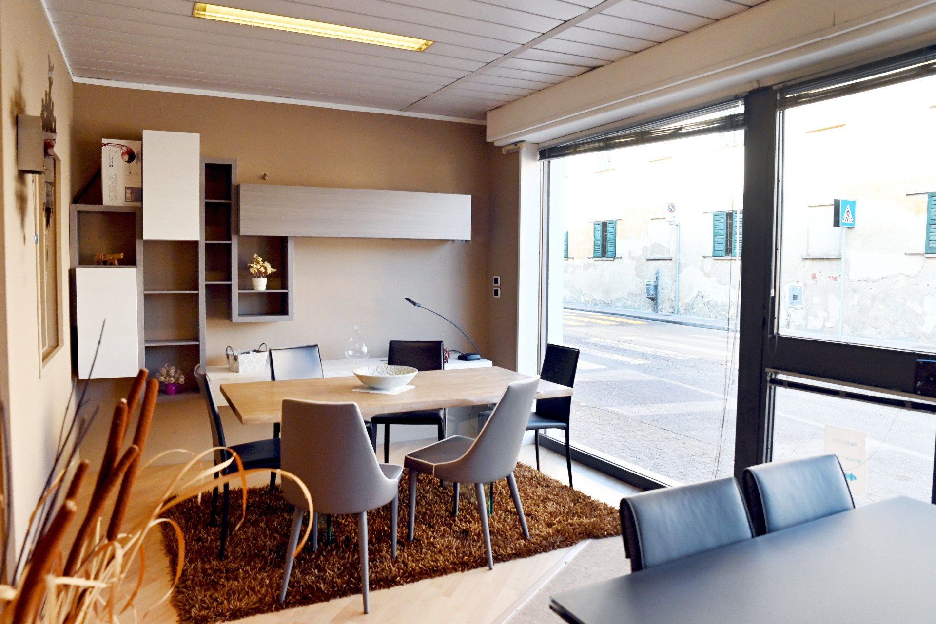 Sala riunioni moderna con tavolo, sedie, scaffali e ampie finestre con vista sull'esterno.