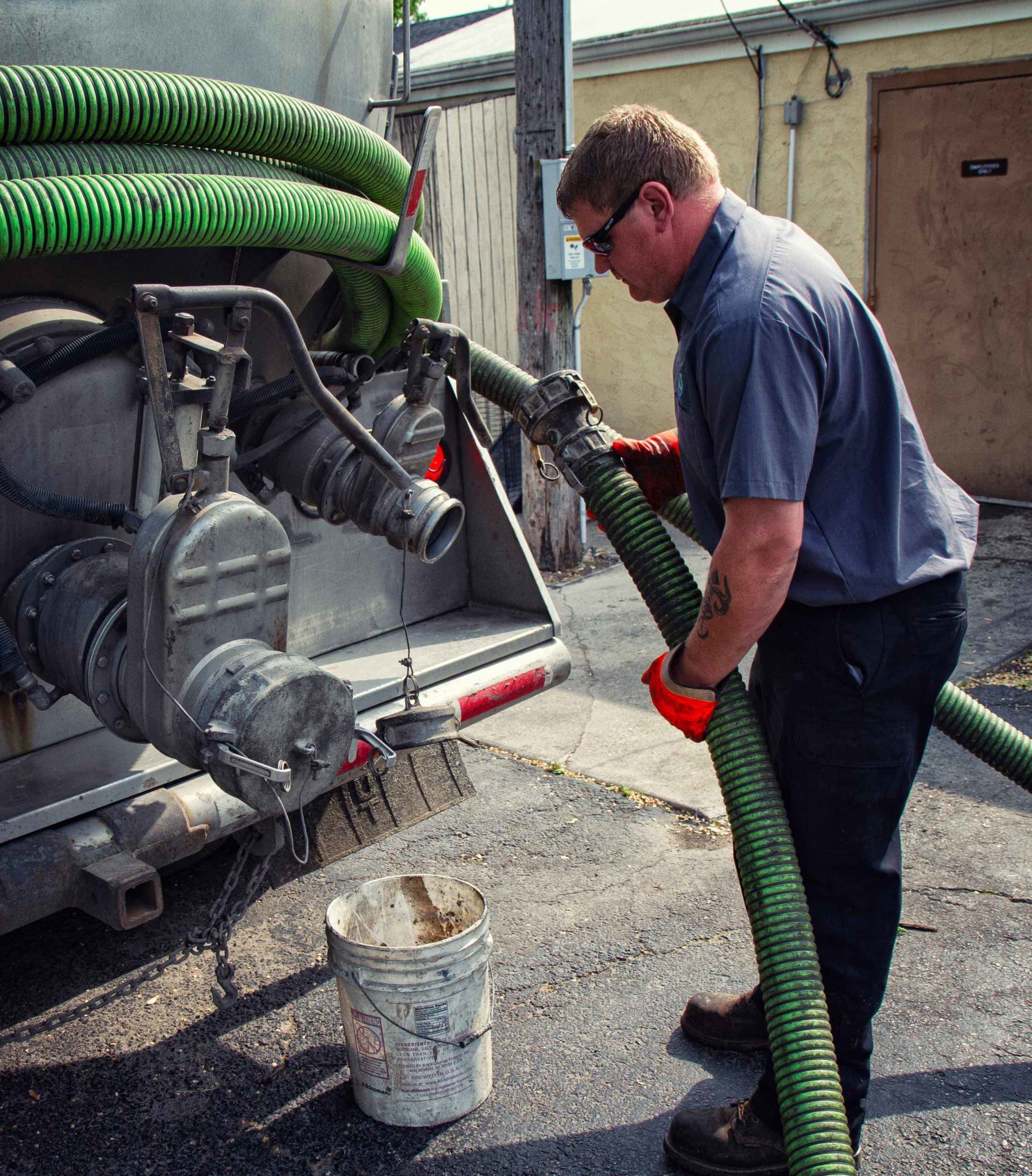 Man Holding the Hose from the Truck — Clyman, WI — United Septic & Drain Services Inc