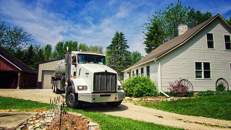 Septic Truck Outside the House — Clyman, WI — United Septic & Drain Services Inc Septic Truck Outside the House — Clyman, WI — United Septic & Drain Services Inc