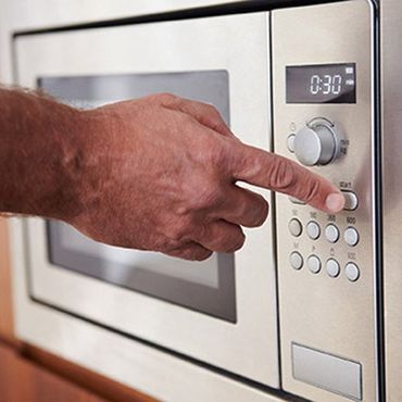 Home Appliance Repair — Man Using Microwave in Bountiful, UT Home Appliance Repair — Man Using Microwave in Bountiful, UT