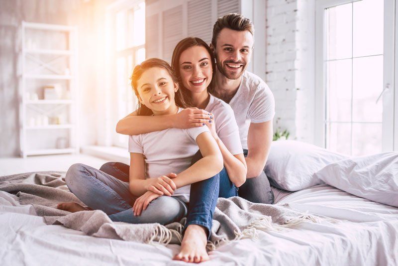 Cockroaches — Happy Family Sitting on the Clean Bed in Tavares, FL