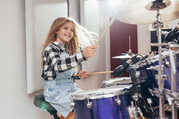 young girl playing drums
