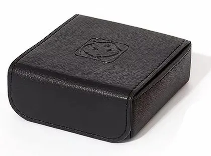 A black leather box with a logo on it is sitting on a white surface.
