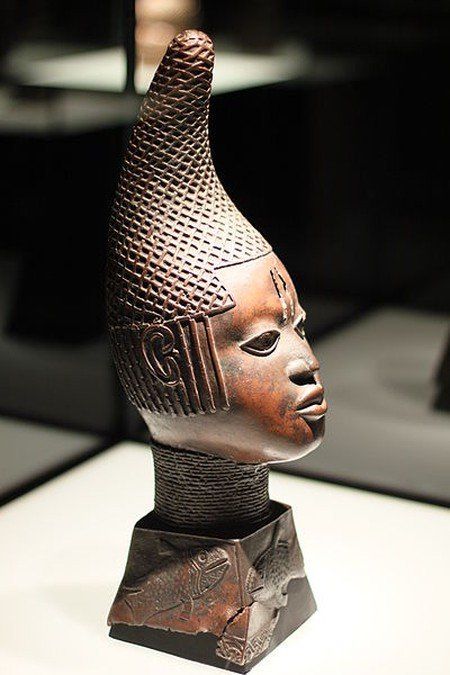 A statue of a man 's head with a conical hat on a pedestal.