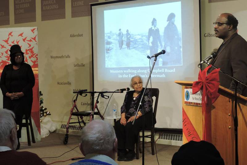 A man is standing at a podium giving a presentation to a group of people.