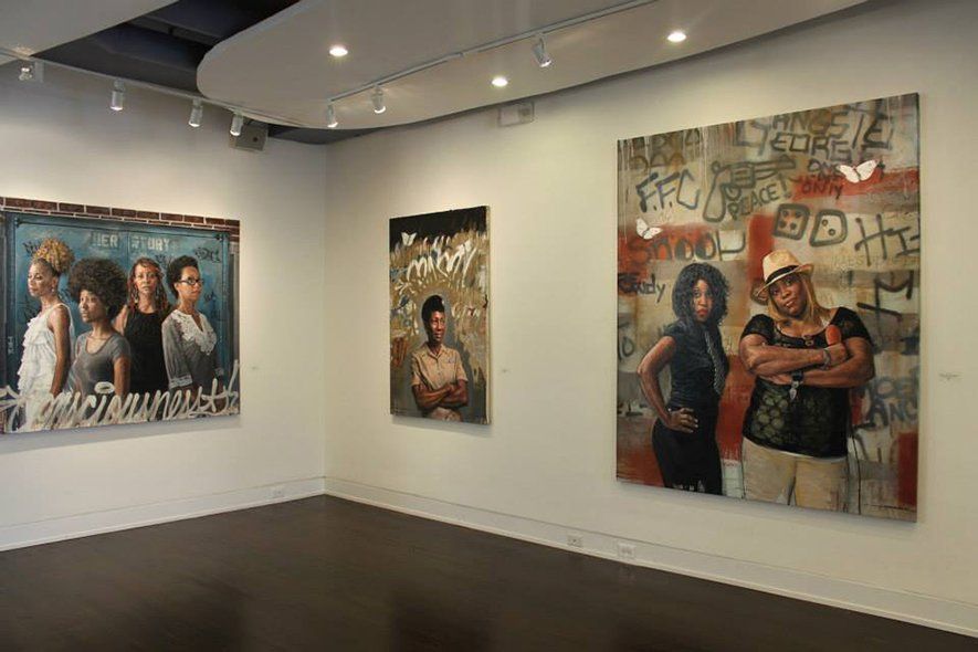 A room with a lot of paintings on the wall.