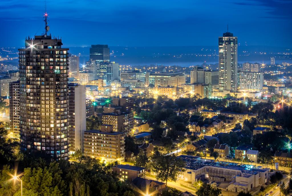 An aerial view of a city at night with lots of buildings lit up.