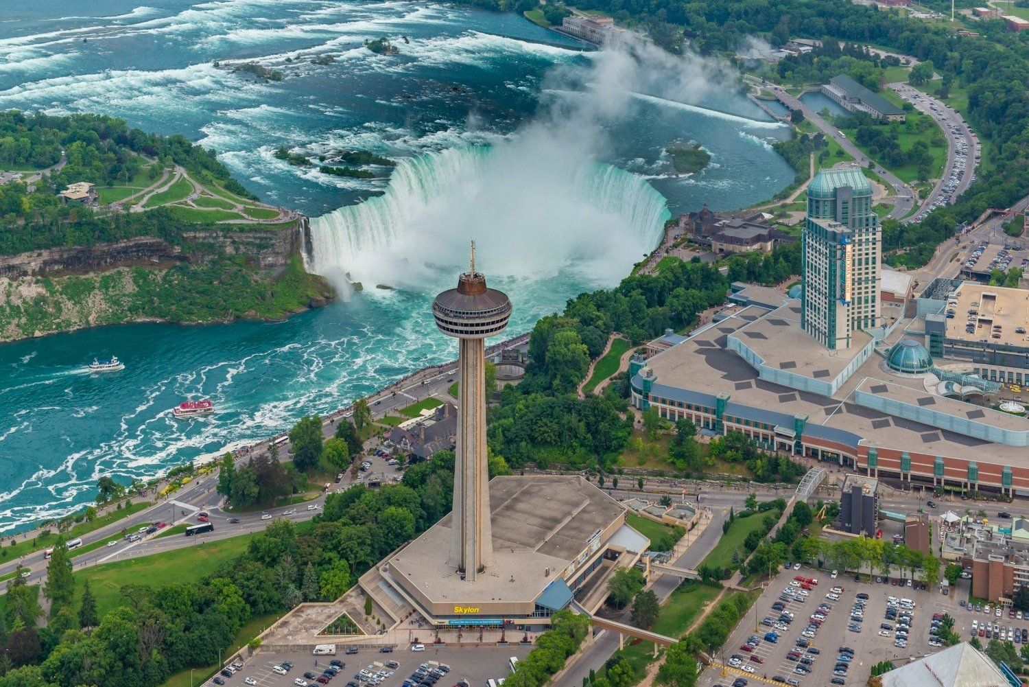 An aerial view of the niagara falls with a tower in the foreground.