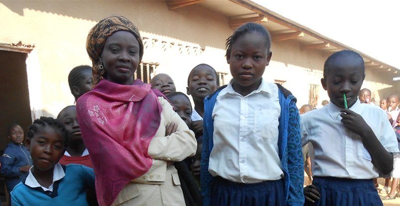 A group of children are standing in front of a building.
