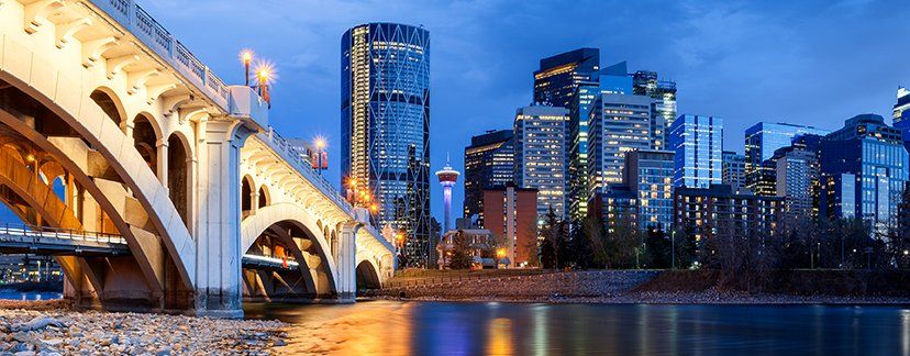 A bridge over a river with a city skyline in the background.