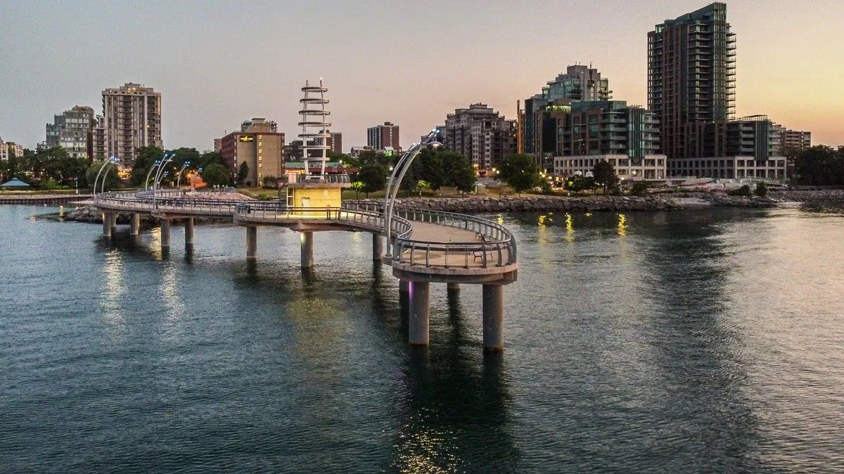 An aerial view of a pier overlooking a body of water with a city in the background.