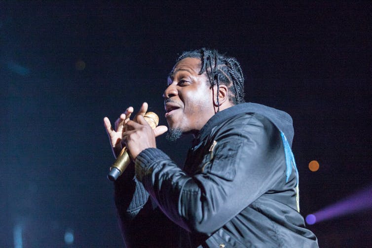 A man is singing into a microphone on a stage.