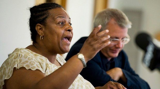 A woman is talking to a man while sitting at a table.
