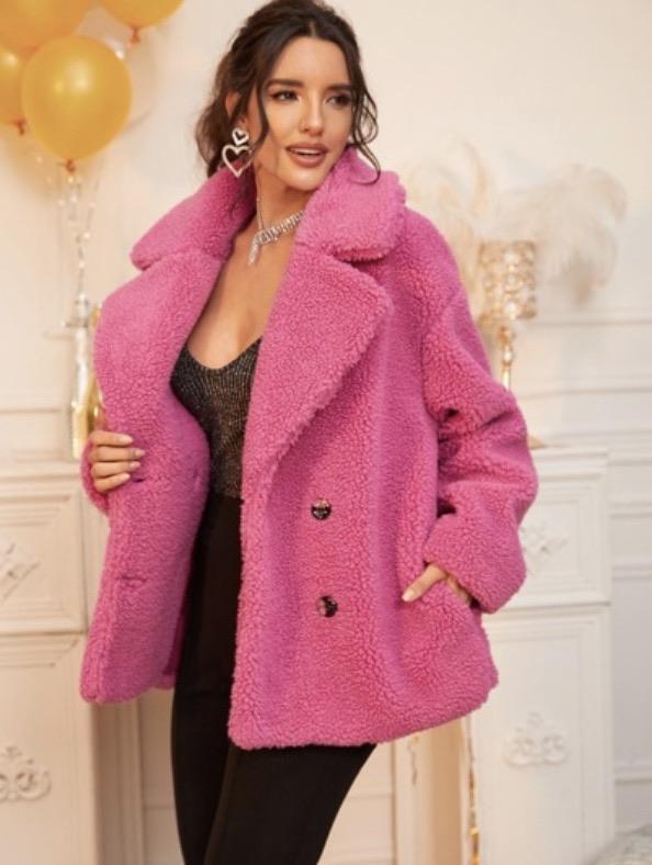 A woman is wearing a pink teddy bear coat