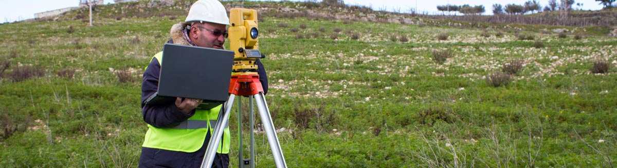 Surveyor with computer in field Surveyor with computer in field