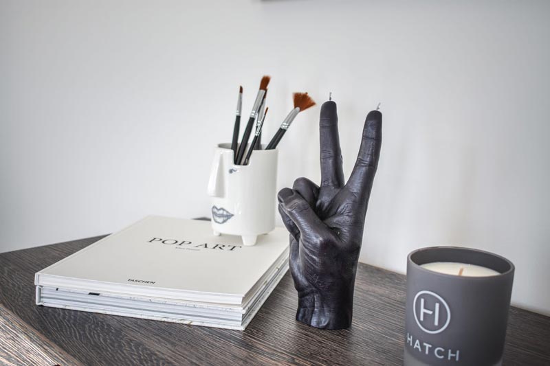 A ceramic hand decoration next to some paperwork