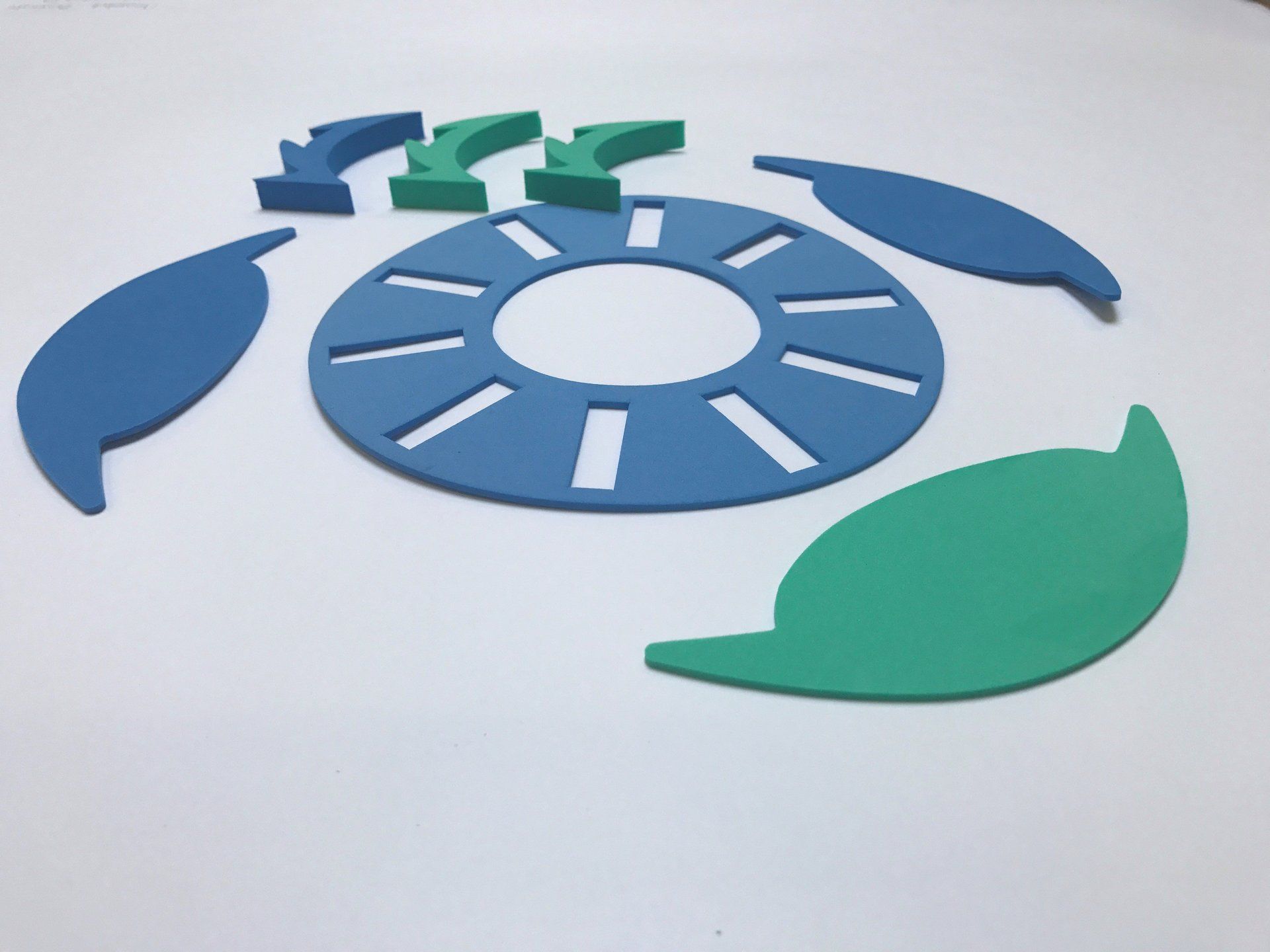 Blauwe en groene schildpadpuzzelstukjes op een witte ondergrond.