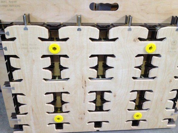 Houten pallet met uitsparingen en gele bevestigingsmaterialen.