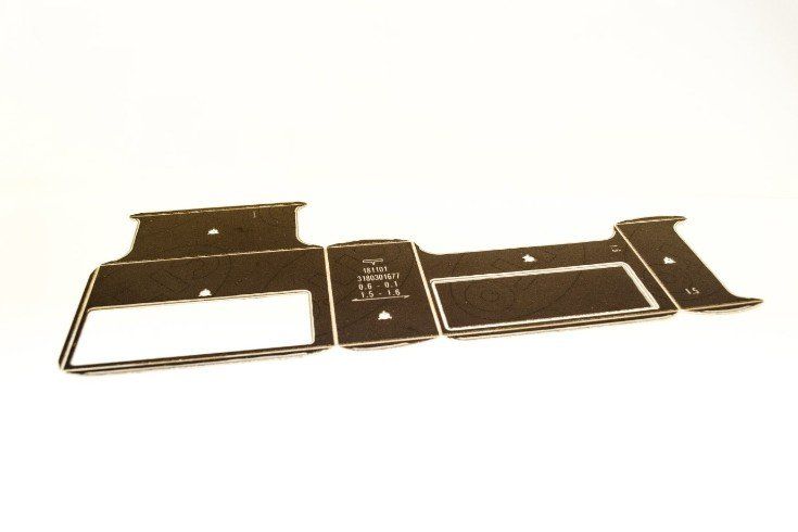 Zwart gestanst knutselpapier met rechthoekige en gebogen vormen, op een witte ondergrond.