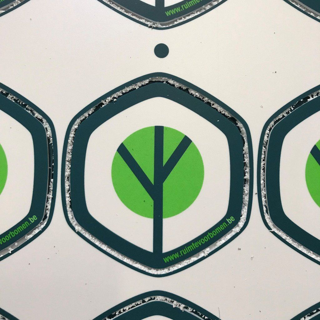 Herhalend patroon van groene bomen binnen turquoise zeshoeken op een witte achtergrond.