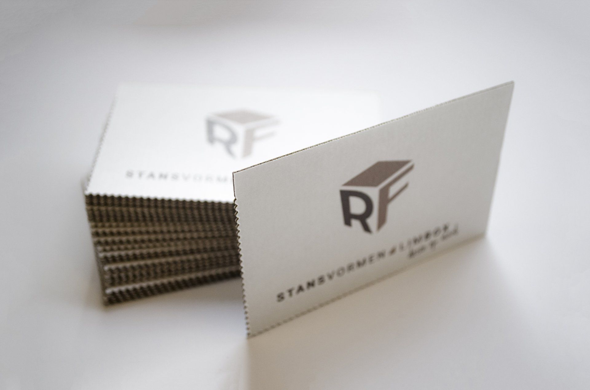 Een stapel witte visitekaartjes met het logo 