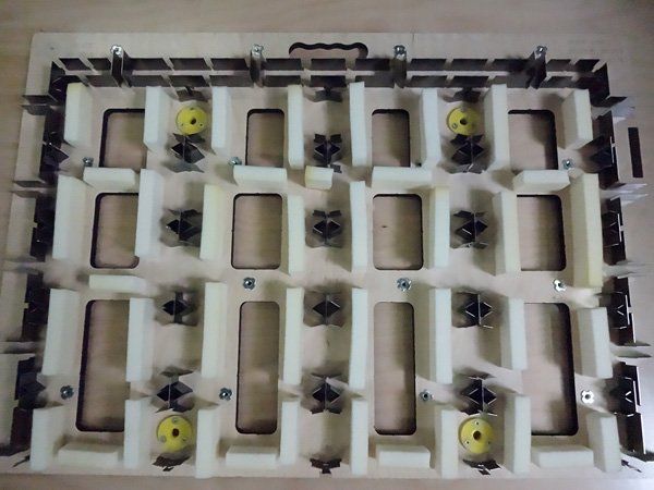 Stansmachine met rechthoekige openingen en metalen messen.