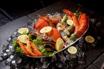 Un plato de mariscos está sobre hielo sobre una mesa.