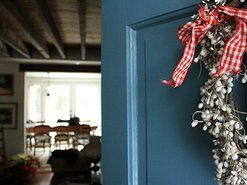 A wreath is hanging on a blue door in a living room.